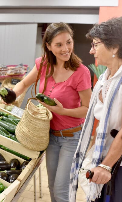 senior woman going to grocery store with help of carer