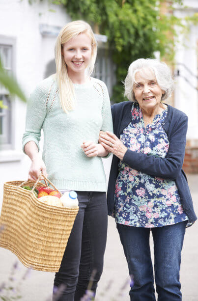 Young lady carrying basket and elderly woman smiling