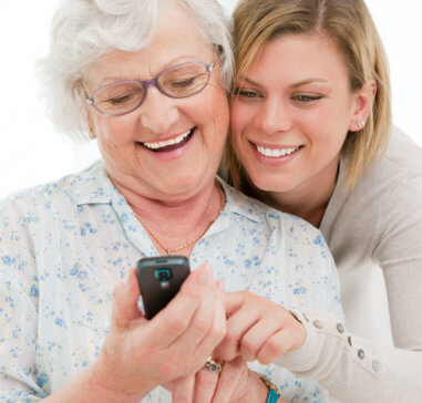 elderly woman and young lady smiling looking at a cellphone